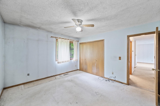 unfurnished bedroom featuring baseboards, a closet, carpet floors, and ceiling fan