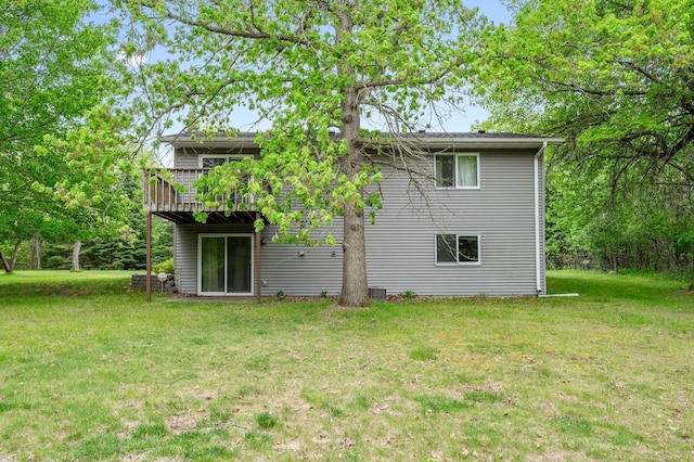 rear view of house featuring a lawn and a wooden deck