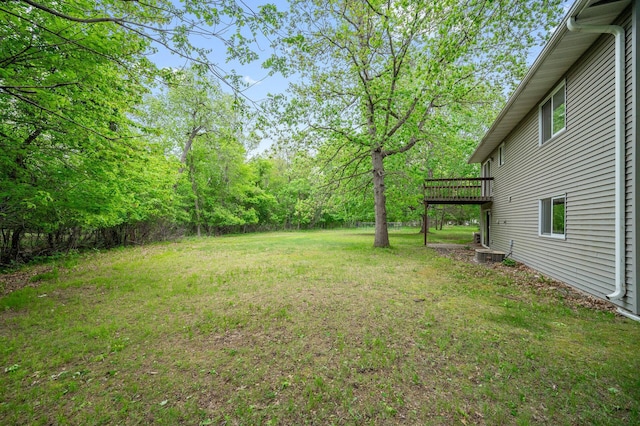 view of green lawn featuring a wooden deck