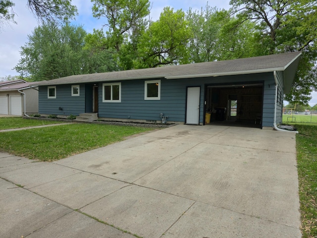 214 Central Ave, Truman, MN 56088 - ranch-style house featuring a front lawn, entry steps, and a detached garage