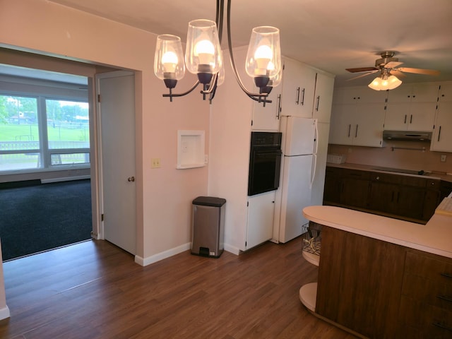 214 Central Ave, Truman, MN 56088 - kitchen with oven, under cabinet range hood, freestanding refrigerator, white cabinetry, and dark wood-type flooring