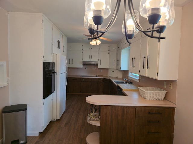 214 Central Ave, Truman, MN 56088 - kitchen with black appliances, a sink, dark wood-type flooring, light countertops, and under cabinet range hood