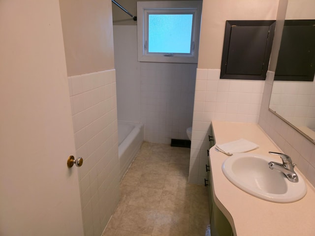 214 Central Ave, Truman, MN 56088 - full bath with tile walls, vanity, tile patterned flooring, toilet, and a wainscoted wall