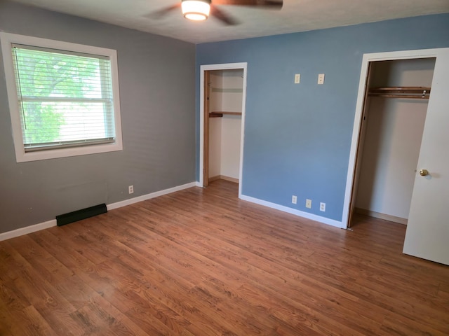214 Central Ave, Truman, MN 56088 - unfurnished bedroom with two closets, wood finished floors, and baseboards