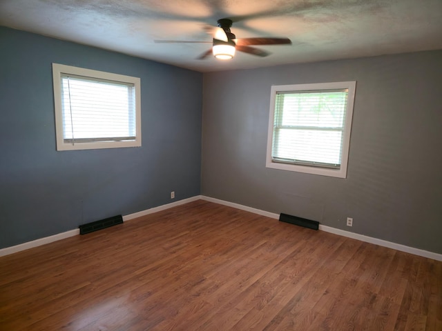 214 Central Ave, Truman, MN 56088 - empty room featuring ceiling fan, wood finished floors, and baseboards