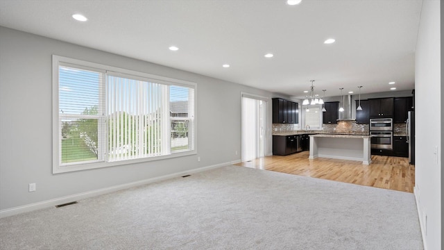 15365 Eagle Creek Way, Apple Valley, MN 55124 - unfurnished living room featuring light colored carpet, recessed lighting, baseboards, a sink, and a chandelier