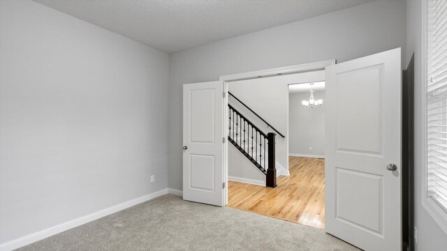 15365 Eagle Creek Way, Apple Valley, MN 55124 - carpeted spare room featuring a chandelier, baseboards, and stairs