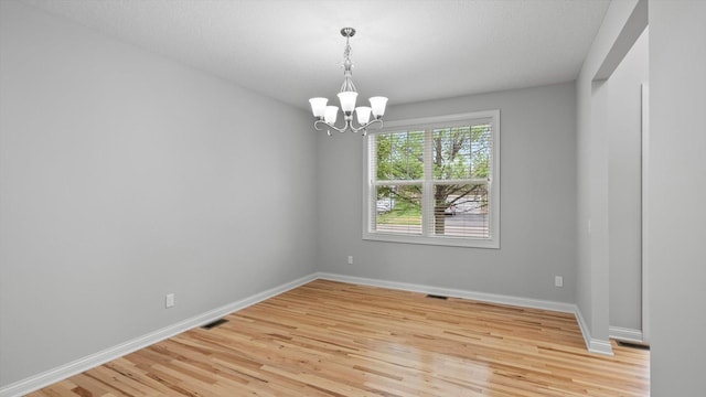 15365 Eagle Creek Way, Apple Valley, MN 55124 - unfurnished room with light wood-style flooring, a chandelier, and baseboards