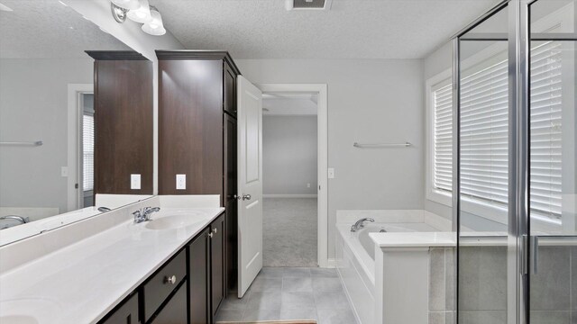15365 Eagle Creek Way, Apple Valley, MN 55124 - bathroom featuring a textured ceiling, tile patterned flooring, a bath, double vanity, and baseboards