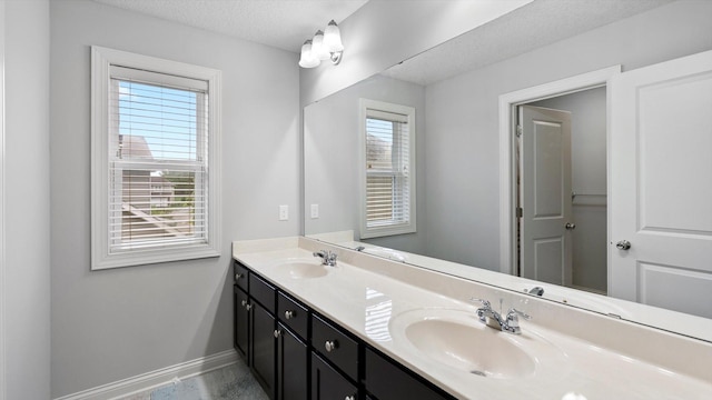 15365 Eagle Creek Way, Apple Valley, MN 55124 - bathroom featuring baseboards, double vanity, and a textured ceiling