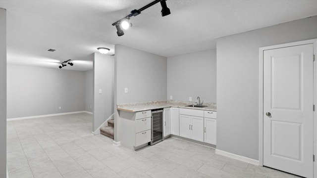 15365 Eagle Creek Way, Apple Valley, MN 55124 - indoor wet bar with wine cooler, track lighting, a textured ceiling, baseboards, and stairway