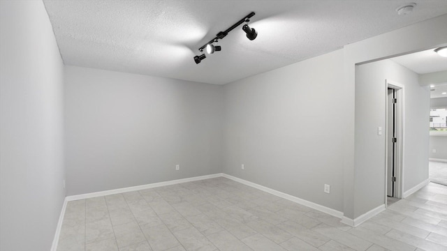 15365 Eagle Creek Way, Apple Valley, MN 55124 - spare room featuring a textured ceiling, a smoke detector, rail lighting, and baseboards