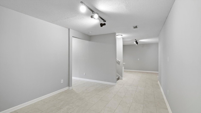 15365 Eagle Creek Way, Apple Valley, MN 55124 - empty room with a textured ceiling, track lighting, stairway, and baseboards