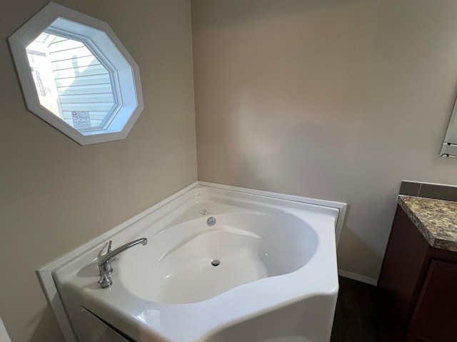 bathroom with vanity and a bath