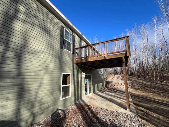 view of side of home featuring a patio and a wooden deck