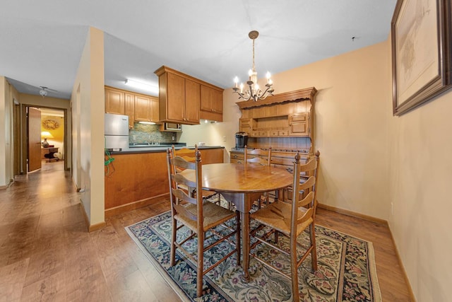 5450 Three Points Blvd Unit 623, Mound, MN 55364 - dining space with light wood-style flooring, a chandelier, and baseboards
