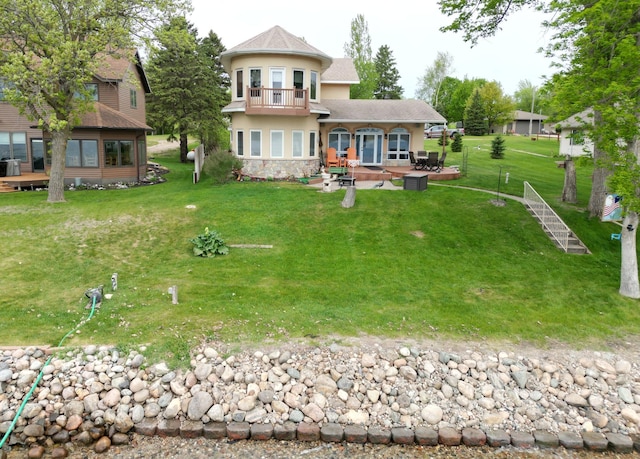 14620 Thomas Rd, Lake Park, MN 56554 - rear view of property featuring a balcony, stucco siding, a patio area, stone siding, and a lawn