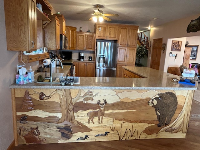 14620 Thomas Rd, Lake Park, MN 56554 - kitchen with stainless steel appliances, brown cabinetry, wood finished floors, ceiling fan, and a breakfast bar area