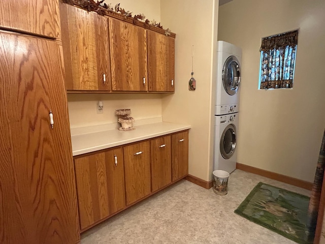 14620 Thomas Rd, Lake Park, MN 56554 - laundry area featuring stacked washer / dryer, cabinet space, baseboards, and light floors