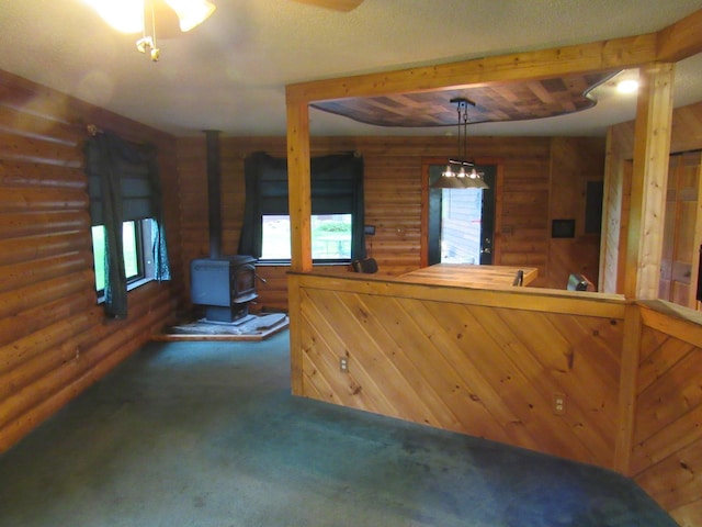 4054 Aspen Rd, Moose Lake, MN 55767 - interior space with carpet flooring, a wood stove, rustic walls, and pendant lighting