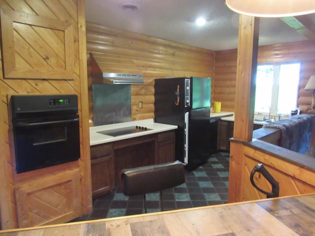 4054 Aspen Rd, Moose Lake, MN 55767 - kitchen with black appliances, rustic walls, under cabinet range hood, and brown cabinets