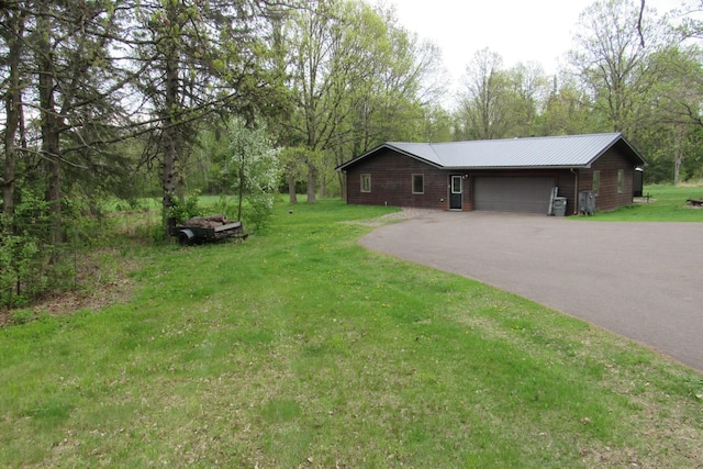 4054 Aspen Rd, Moose Lake, MN 55767 - view of property exterior with driveway, a lawn, a garage, and a metal roof
