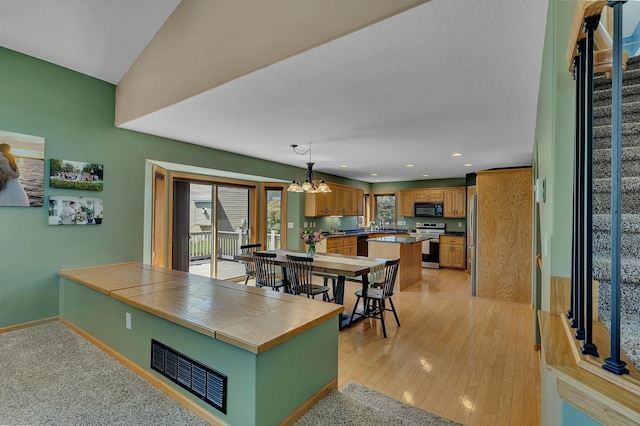 23807 Brendan Way, Rogers, MN 55374 - kitchen featuring black appliances, a chandelier, recessed lighting, a center island, and light wood finished floors