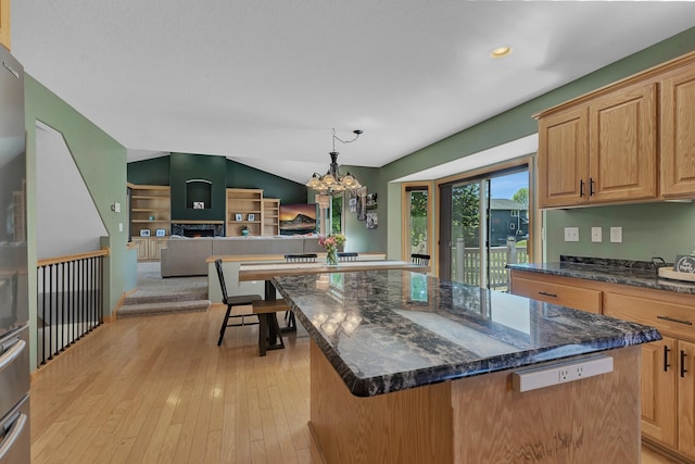 23807 Brendan Way, Rogers, MN 55374 - kitchen with a kitchen island, lofted ceiling, a chandelier, open floor plan, and dark stone counters