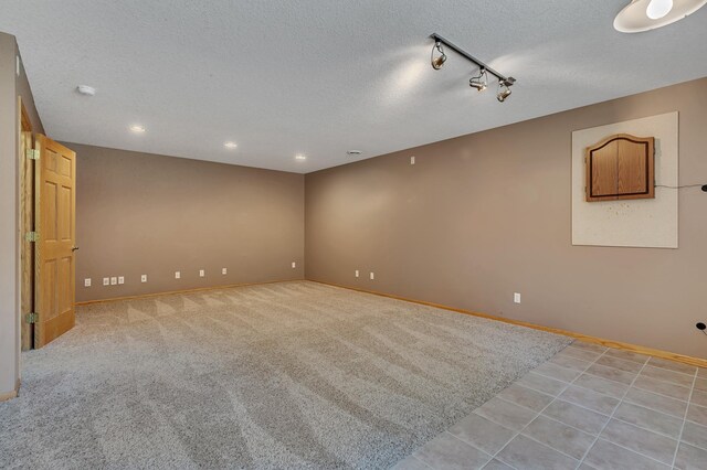 23807 Brendan Way, Rogers, MN 55374 - spare room with baseboards, a textured ceiling, rail lighting, recessed lighting, and light tile patterned floors