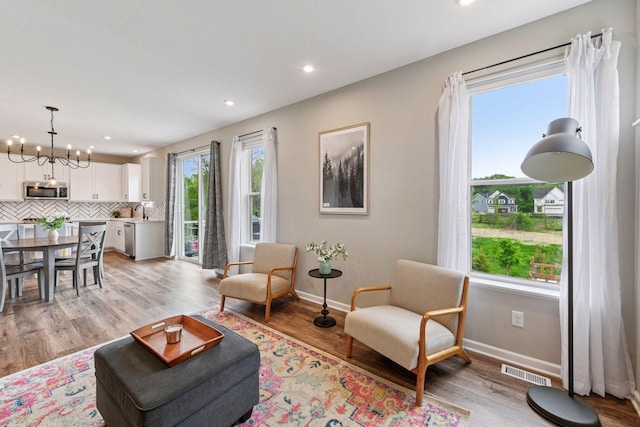 1049 Fabel Ln, Waconia, MN 55387 - living room with a chandelier, baseboards, light wood-type flooring, and recessed lighting