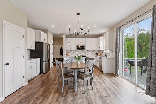 1049 Fabel Ln, Waconia, MN 55387 - dining area with a chandelier, light wood-type flooring, and recessed lighting