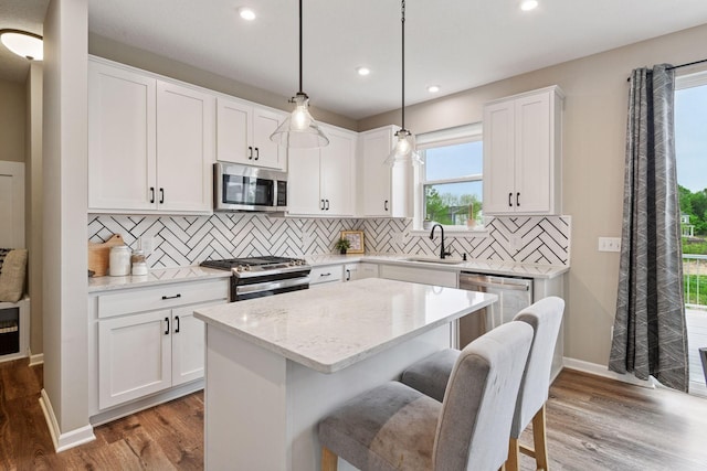 1049 Fabel Ln, Waconia, MN 55387 - kitchen featuring appliances with stainless steel finishes, a sink, light wood-type flooring, a center island, and recessed lighting