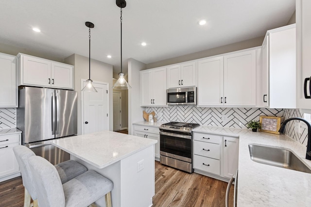 1049 Fabel Ln, Waconia, MN 55387 - kitchen with appliances with stainless steel finishes, a sink, a center island, tasteful backsplash, and dark wood-style floors