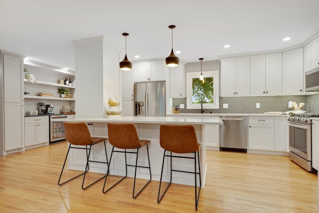 2400 Oakwood Dr, Burnsville, MN 55306 - kitchen featuring stainless steel appliances, wine cooler, light wood finished floors, white cabinets, and recessed lighting