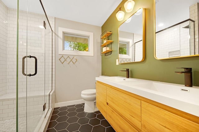 2400 Oakwood Dr, Burnsville, MN 55306 - bathroom featuring tile patterned floors, a shower stall, toilet, and double vanity
