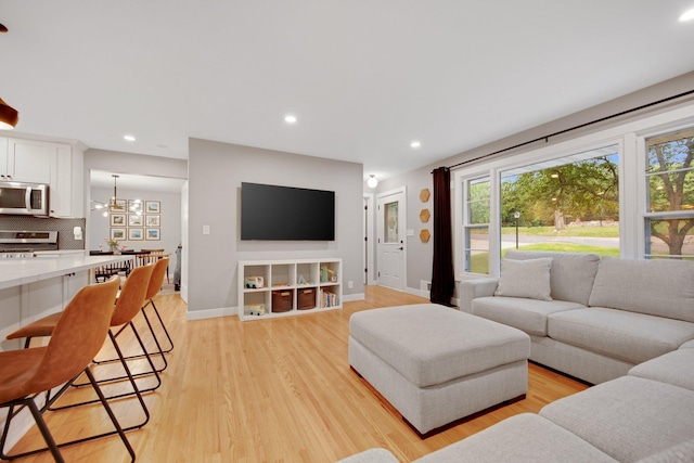 2400 Oakwood Dr, Burnsville, MN 55306 - living room with plenty of natural light, light wood-style flooring, baseboards, recessed lighting, and a chandelier