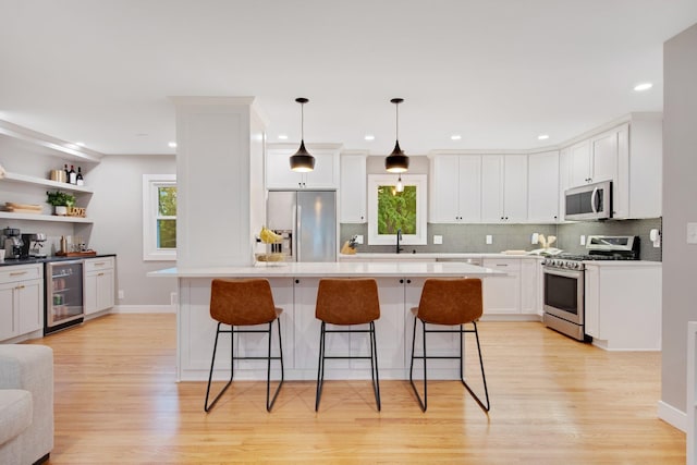 2400 Oakwood Dr, Burnsville, MN 55306 - kitchen featuring appliances with stainless steel finishes, wine cooler, a breakfast bar, light wood finished floors, and recessed lighting