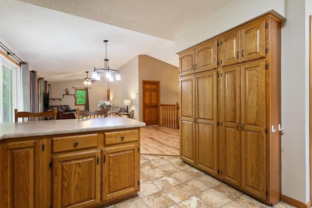 W1618 850th Ave, Spring Valley, WI 54767 - kitchen with vaulted ceiling, pendant lighting, light countertops, brown cabinets, and open floor plan