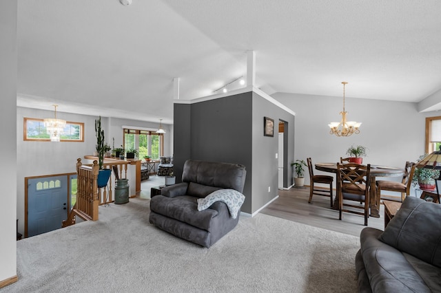 3062 196th Ave NE, East Bethel, MN 55011 - living room featuring a chandelier, rail lighting, vaulted ceiling, carpet flooring, and baseboards