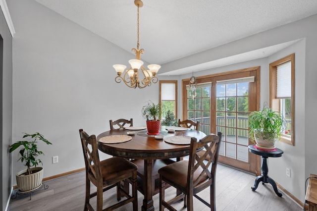 3062 196th Ave NE, East Bethel, MN 55011 - dining room featuring baseboards, light wood finished floors, a chandelier, and vaulted ceiling