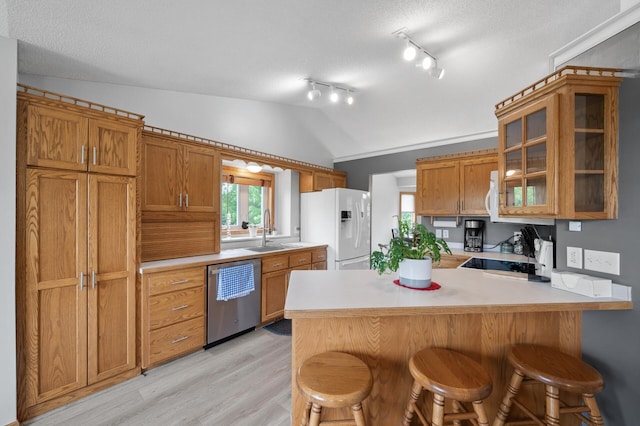 3062 196th Ave NE, East Bethel, MN 55011 - kitchen with dishwasher, white refrigerator with ice dispenser, vaulted ceiling, a peninsula, and a breakfast bar