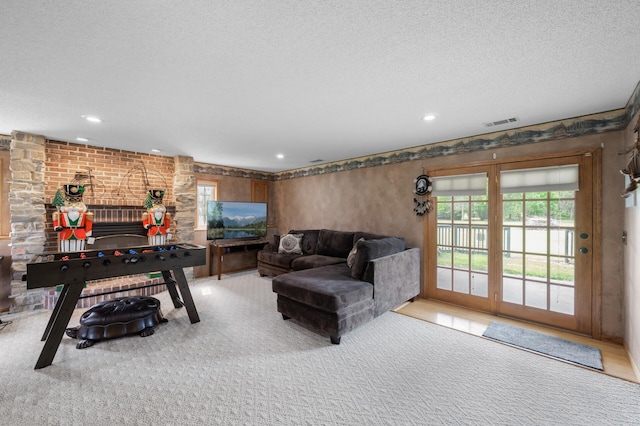 3062 196th Ave NE, East Bethel, MN 55011 - living room featuring healthy amount of natural light, a textured ceiling, a fireplace, carpet flooring, and recessed lighting
