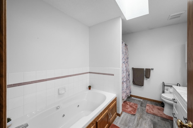 3062 196th Ave NE, East Bethel, MN 55011 - bathroom featuring a skylight, wood finished floors, a tub with jets, toilet, and baseboards