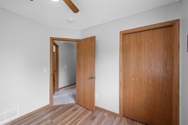 3062 196th Ave NE, East Bethel, MN 55011 - unfurnished bedroom with light wood-style floors, a closet, baseboards, and a ceiling fan