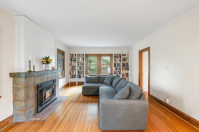 2708 Chowen Ave S, Minneapolis, MN 55416 - living room with light wood-style flooring, a tile fireplace, baseboards, crown molding, and built in shelves