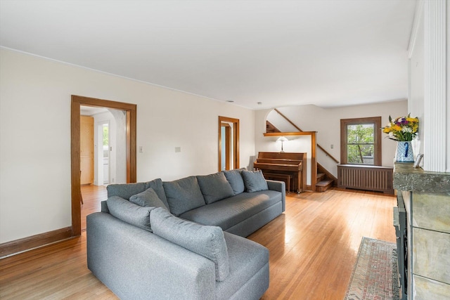 2708 Chowen Ave S, Minneapolis, MN 55416 - living area featuring radiator heating unit, stairs, light wood-style flooring, and baseboards