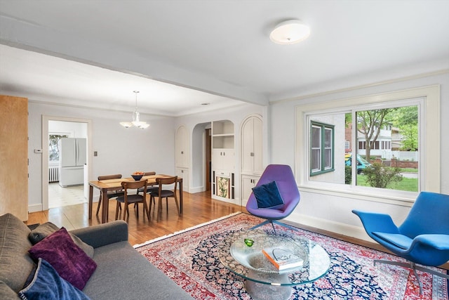 2708 Chowen Ave S, Minneapolis, MN 55416 - living area featuring baseboards, arched walkways, a chandelier, light wood-style flooring, and crown molding