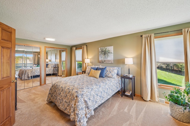 2929 170th St, Frederic, WI 54837 - bedroom with light carpet, two closets, a textured ceiling, and baseboards
