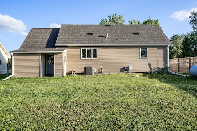 back of property featuring central AC unit and a shingled roof