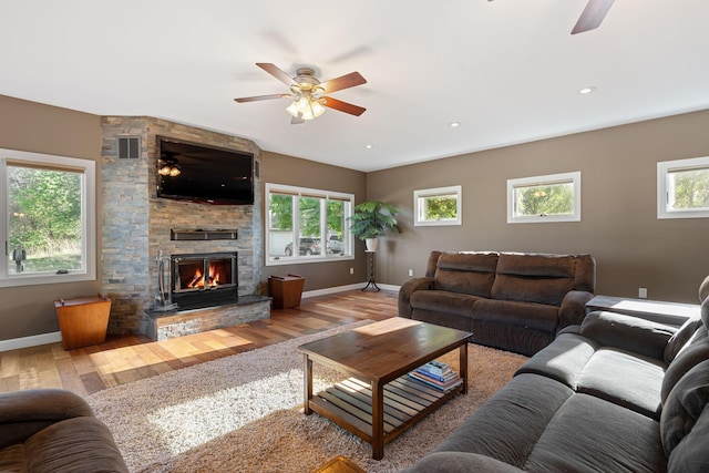 living area with a ceiling fan, wood finished floors, and baseboards